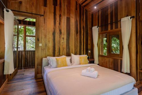 a bedroom with a bed with two towels on it at Payana Kampot in Kampot