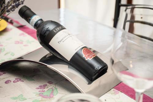 a bottle of wine sitting on a table next to a glass at Casa Ludovica in Manduria