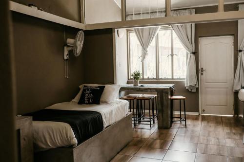 a bedroom with a bed and a table and a window at Overnight Stop Before Kruger National Park in Phalaborwa