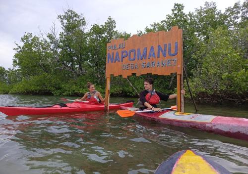 two children are sitting on kayaks in the water at Pondok Wisata Tasya Marawuwung in Likupang
