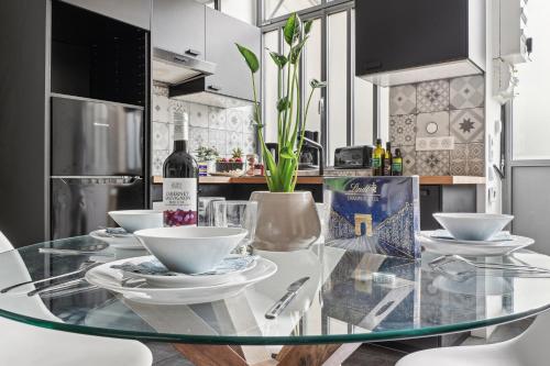 - une table en verre dans la cuisine avec une bouteille de vin dans l'établissement Lavie Maison - Charm in Marais, à Paris