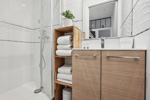 une salle de bain avec un lavabo, un miroir et des serviettes dans l'établissement Lavie Maison - Charm in Marais, à Paris