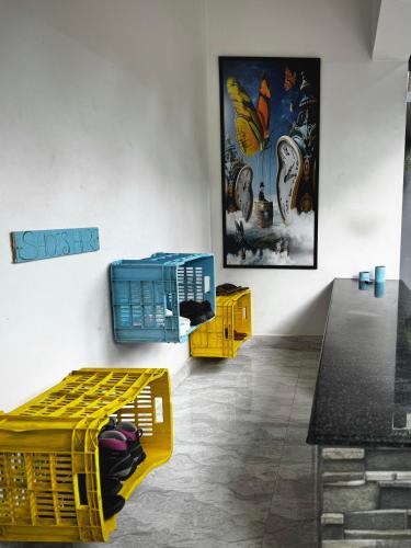 a room with two yellow tables and a painting on the wall at The Yellow Submarine in Varkala