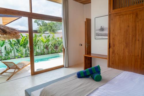 a bedroom with a bed and a view of a pool at Villa Lucilla, beautiful Villa in the heart of Uluwatu in Uluwatu