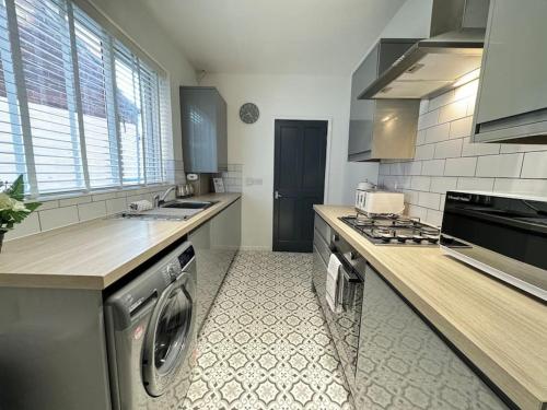 a kitchen with a washing machine and a sink at Park Apartment 1, close to Tynemouth in Tynemouth