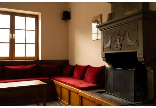 a living room with a red couch and a fireplace at Armoloi Traditional - Guest House in Konitsa