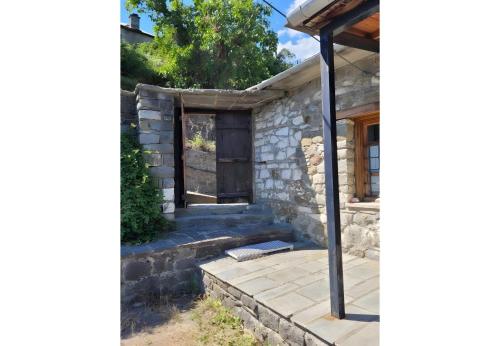 a stone house with a porch and a patio at Armoloi Traditional - Guest House in Konitsa