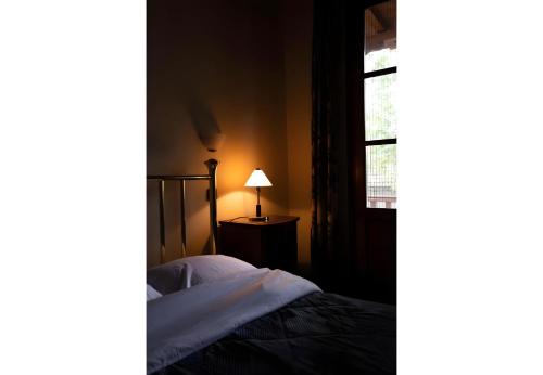 a bedroom with a bed and a lamp next to a window at Armoloi Traditional - Guest House in Konitsa