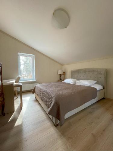 a bedroom with a bed and a desk and a window at The Paradise House in Riga