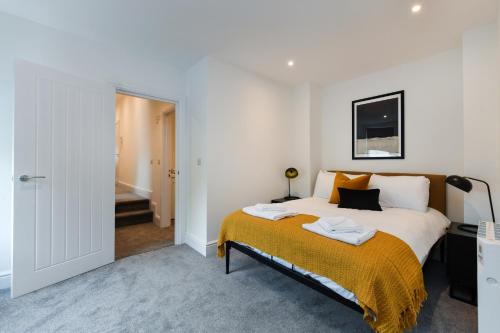 een slaapkamer met een bed met een gele deken bij Charming 2Bed Flat - Spacious & Prime Location in Nottingham