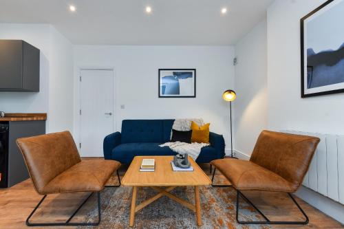 een woonkamer met een blauwe bank en twee stoelen bij Charming 2Bed Flat - Spacious & Prime Location in Nottingham