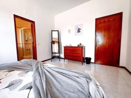 een slaapkamer met een bed, een ladekast en een spiegel bij Big Private Room W bathroom in Oeiras