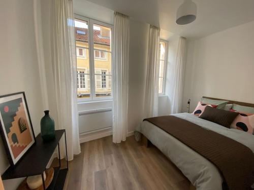 une chambre avec un lit et une grande fenêtre dans l'établissement La parenthèse T2 tout neuf moderne et chaleureux, à Chalon-sur-Saône