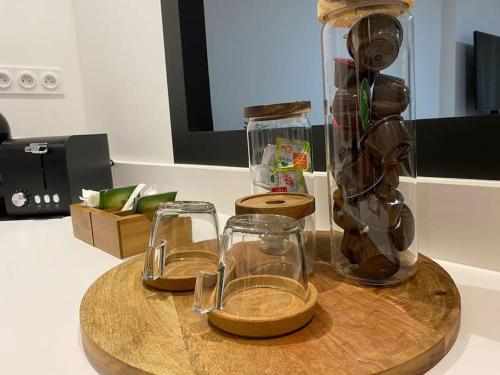 deux verres et un vase sur une table en bois dans l'établissement La parenthèse T2 tout neuf moderne et chaleureux, à Chalon-sur-Saône