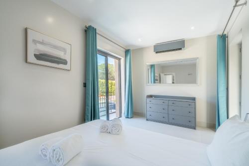 a bedroom with a white bed and a window at Vilamoura Pine Hills with Pool by Homing in Vilamoura