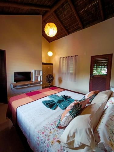 a bedroom with a large bed and a television at Pipa Om in Pipa