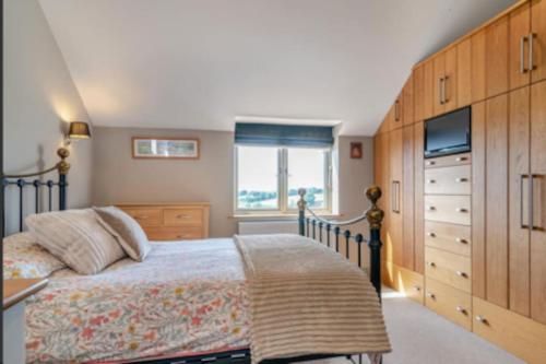 a bedroom with a large bed and a dresser at Tranquil 4-bed Spectacular Views in Much Birch