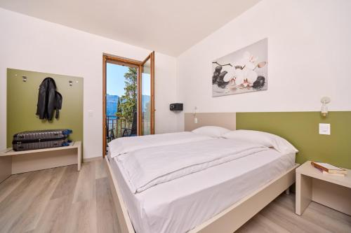 a bedroom with a large bed and a balcony at Casa Milani in Malcesine