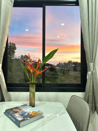 a table with a vase on it with a window at Cozy Vazn House Krabi Klong Muang in Ban Khao Klom