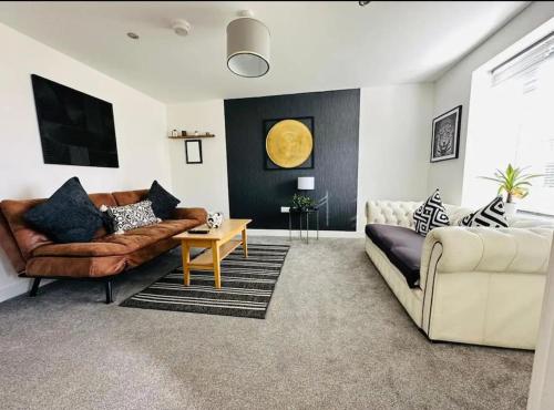 a living room with a couch and a table at Ashford Luxury House with Hot tub and Driveway Parking in Kingsnorth