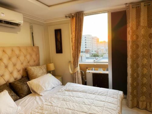 a bedroom with a bed and a large window at Cozy Apartment with a King Bed in Lahore