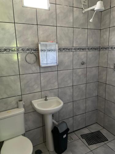 a bathroom with a toilet and a sink at Chácara Arco Íris in Conde