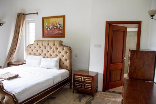 a bedroom with a large bed and a table at Family 3bed House in Kampala