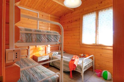 a bedroom with bunk beds in a log cabin at Centro Vacanze Verde Azzurro in Cingoli