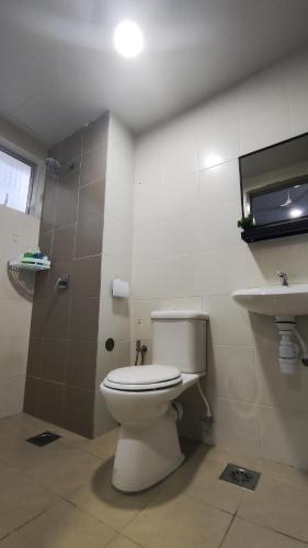 a bathroom with a toilet and a sink at A ONE Holiday Apartment in Tanah Rata