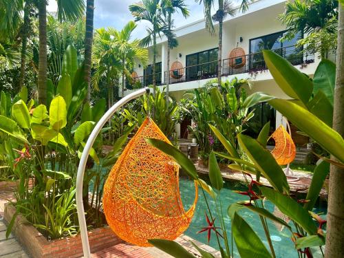 a garden with orange leafed plants and a swimming pool at Enchanted Garden Villas Siem Reap in Siem Reap