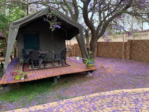 a gazebo with chairs and a table in a yard at Sunset Guesthouse and Venue Cullinan in Meule