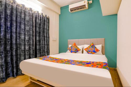 a bedroom with a bed and a window at FabHotel Diamond Stay in Pune