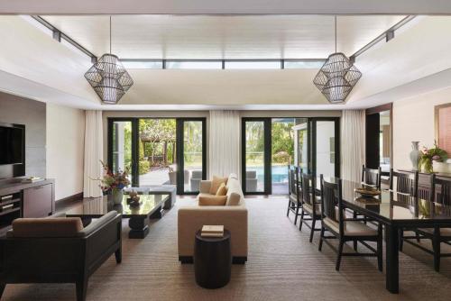 a living room with furniture and a dining room at Raffles Hainan Clear Water Bay in Sanya