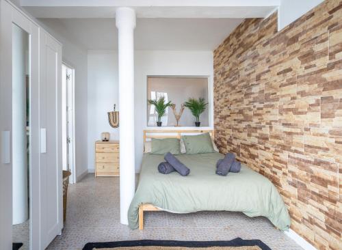 una camera da letto con un muro di mattoni e un letto con cuscini di Calima de Jover a La Laguna