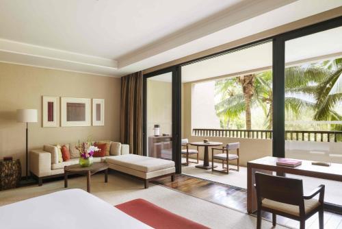 a room with a bed and a living room at Raffles Hainan Clear Water Bay in Sanya