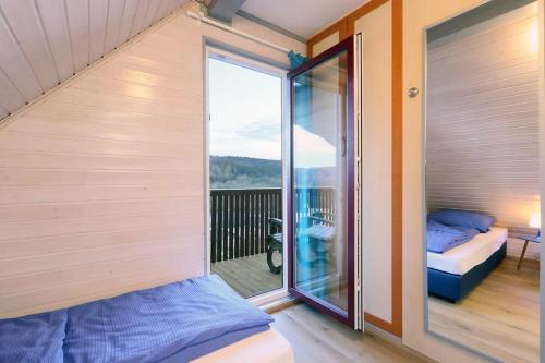 une chambre avec un balcon avec un lit et une fenêtre dans l'établissement Haus Sonnenschein, Seepark Kirchheim, à Kirchheim