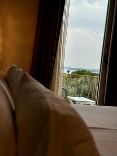 a bedroom with a window with a view of a balcony at Olivi Hotel & Natural Spa in Sirmione