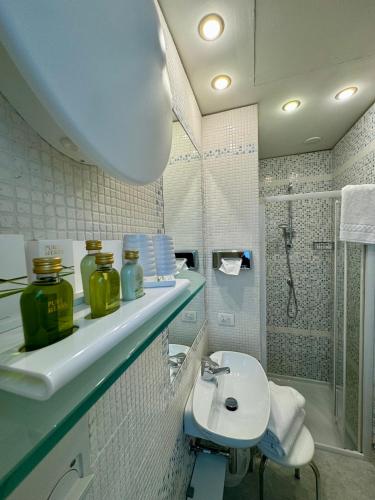 a bathroom with a sink and a toilet and a shower at Olivi Hotel & Natural Spa in Sirmione