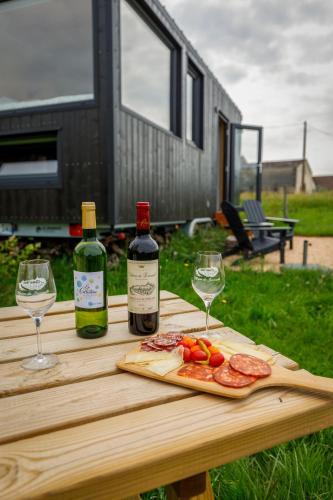 - une table avec 2 bouteilles et 2 verres de vin dans l'établissement Tiny House au milieu des Vignes, à Arbis