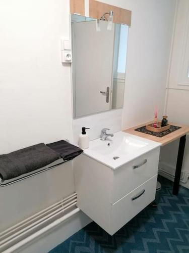 une salle de bain blanche avec un lavabo et un miroir dans l'établissement CHILL 4 pers Boîte à clé 24 sur 7 Netflix & Wifi, à Joinville