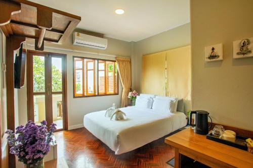 a bedroom with a large white bed and a window at Art house Old City in Chiang Mai