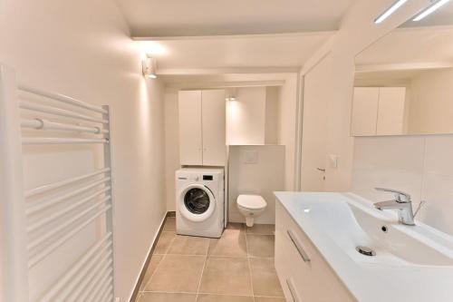 une salle de bain blanche avec une machine à laver et un lavabo dans l'établissement Superbe Loft Central #Marais #Rivoli - II, à Paris