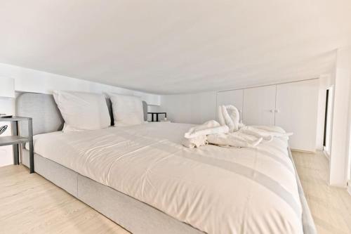 - une chambre blanche avec un grand lit et des draps blancs dans l'établissement Superbe Loft Central #Marais #Rivoli - II, à Paris