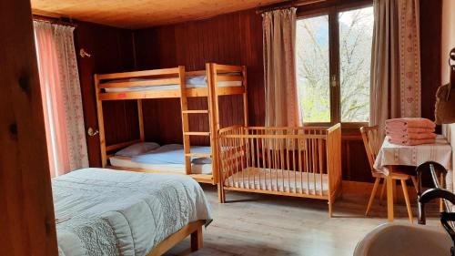 une chambre avec deux lits superposés et une fenêtre dans l'établissement Au Refuge de Blanche, à Verchères