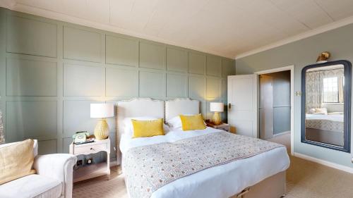a bedroom with a large bed with yellow pillows at Castle Hotel in Taunton