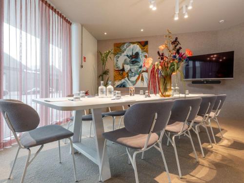 a dining room with a table and chairs with flowers at ibis budget Gent Centrum Dampoort in Ghent