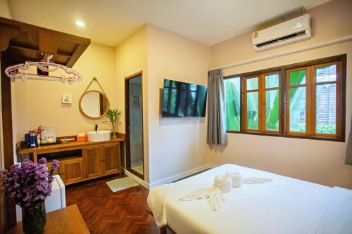 a bedroom with a bed and a sink and a mirror at Art house Old City in Chiang Mai