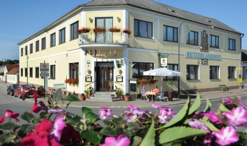 a building on the corner of a street with flowers at Retzerlandhof Familie Graf in Zellerndorf