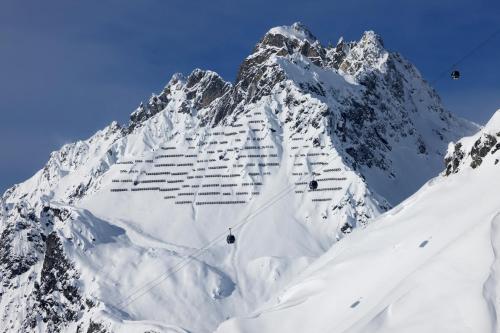 a snow covered mountain with people skiing on it at Valluga Hotel in Sankt Anton am Arlberg