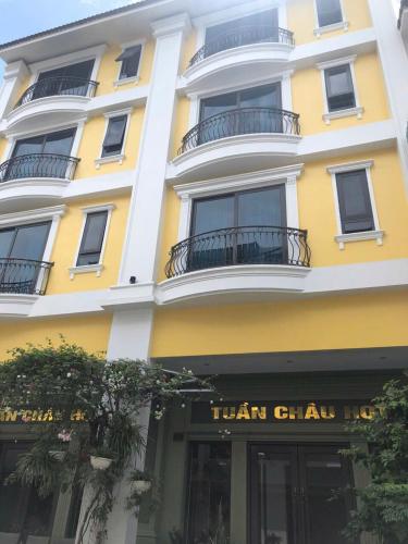 a tall yellow building with a sign for a hair salon at Tuần Châu HQT in Ha Long
